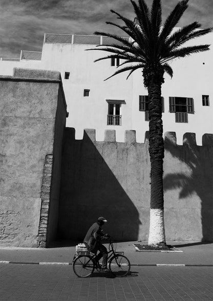 A Man on a Bicycle in Morocco, with a Palm Tree and traditional architecture - Black & White Photography Print A1 A2 A3 - Explura.co
